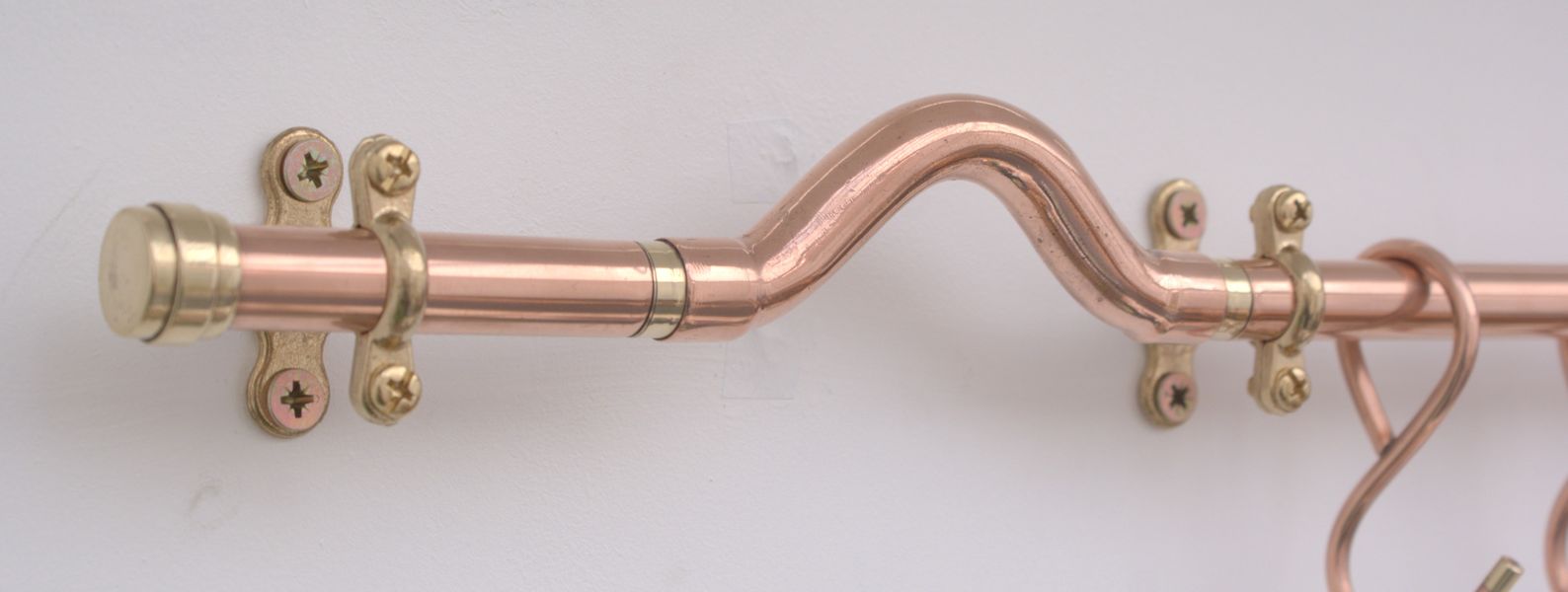 Detail shot of handcrafted copper pan rail, forged in traditional blacksmith workshop