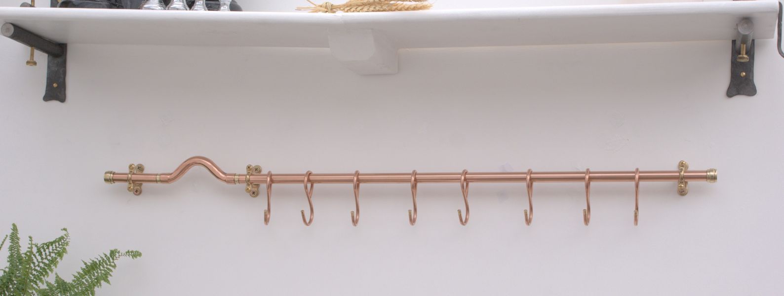 Handmade copper pot rack with modern curved design and six French-style hanging hooks